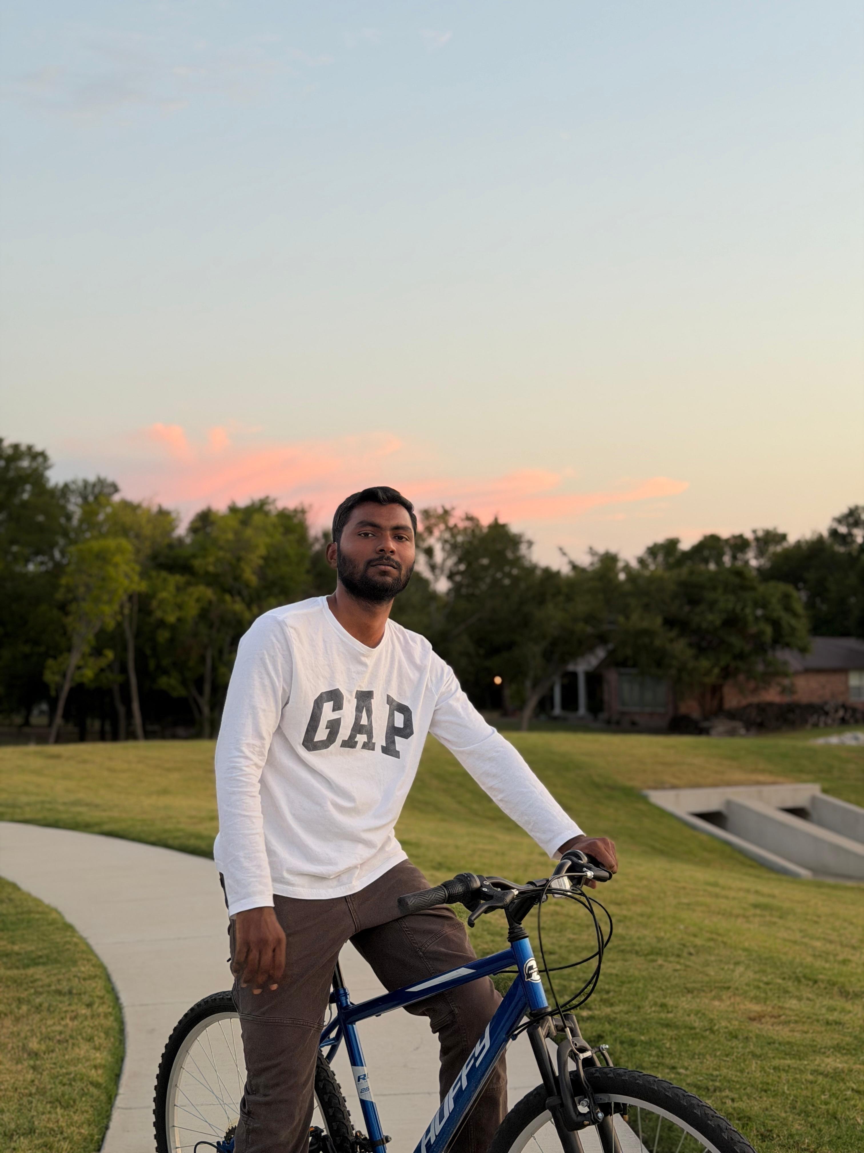 Srikanth Guduri outdoors with his bicycle at sunset